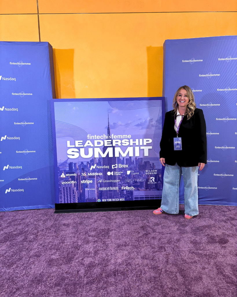 Jessica Johnson stands next to the FinTech is Femme Leadership Summit sign in New York. Image for the article "Jessica Johnson Takes the Stage at FinTech is Femme," highlighting the keyword FinTech is Femme.